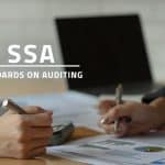 words SSA standards on auditing over background image of two accountants analysing audit reports on a desk with a computer