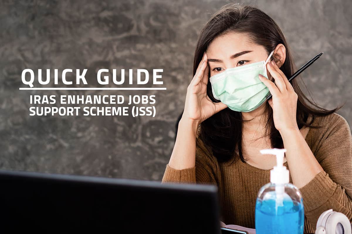 words quick guide iras enhanced jobs support scheme (jss) over background of asian employee wearing a face mask and working on a laptop